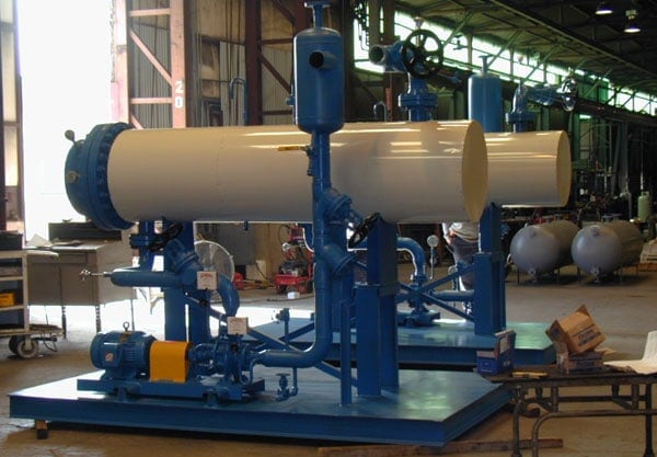 Industrial pump skid with twin horizontal pressure vessels inside fabrication facility